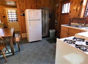 a kitchen with a white refrigerator and a sink at Old Stoney's Musky - Big Arbor Vitae Lake in Arbor Vitae
