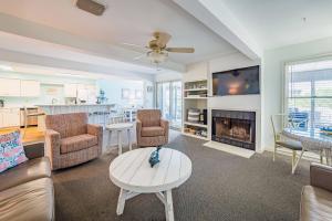 a living room with a couch and a fireplace at K0013 Dunes for Days - Spectacular Oceanfront, Hot Tub & Rec Room! Pets OK! in Nags Head