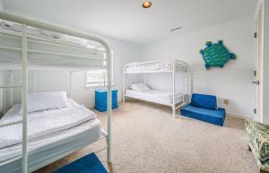 a bedroom with two bunk beds and a blue chair at K0013 Dunes for Days - Spectacular Oceanfront, Hot Tub & Rec Room! Pets OK! in Nags Head +57 photos