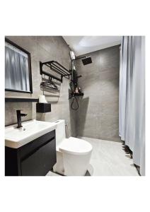 a bathroom with a white toilet and a sink at MI LE GARDEN Chalet in Sekincan