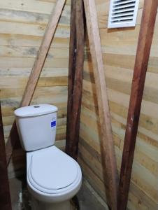 a bathroom with a toilet in a wooden wall at Manglar Eco Resort in La Barra