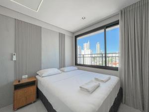 a bedroom with a bed with a large window at Flat Espaçoso com Uma Bela Vista e 2 Quartos in Campo Grande +31 photos