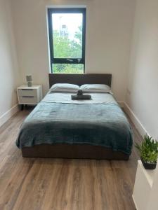 a bedroom with a large bed and a window at Near Old Trafford & Media City 2BR Flat in Manchester