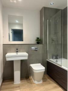 a bathroom with a sink and a toilet and a shower at Near Old Trafford & Media City 2BR Flat in Manchester +15 photos