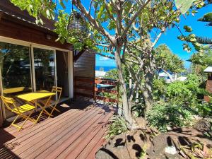 Una terraza de madera con una mesa y sillas. en Studio le Ti coin Charmant, en Saint-Joseph
