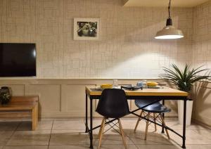 a dining room with a table and chairs and a television at Suite Loc Suite & Spa in Casablanca