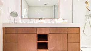 a bathroom with a sink and a mirror at Aurora Mare Saadiyat 1BHK Loft Pool Access in Abu Dhabi