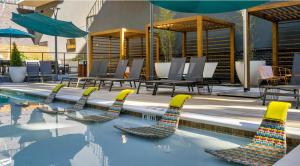 einen Pool mit einigen Stühlen und einem Sonnenschirm in der Unterkunft Luxury 1BR Atlanta Apartment in Atlanta