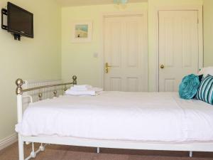 a bedroom with a white bed and a tv at Atlantic View Apartment in Bude +2 photos