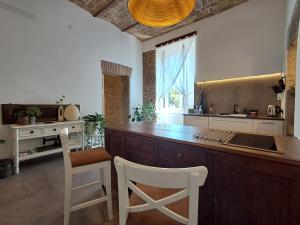 a kitchen with a large wooden island with two chairs at MATA Home in Civitavecchia +27 photos