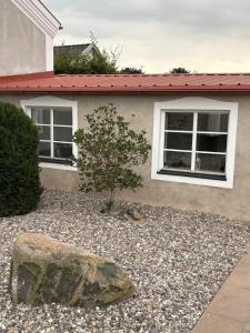 a rock and a tree in front of a house at Gäststugan in Ystad