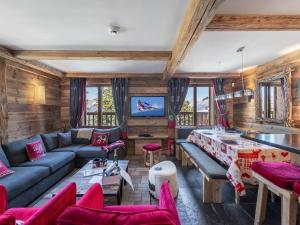 un soggiorno con un divano blu e sedie rosse di Chalet cosy proche des pistes avec sauna et cheminée - Courchevel 1850 - FR-1-564-25 a Courchevel