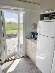 a white refrigerator in a kitchen with a window at 0060-Romo-Lakolk-33 in Lakolk