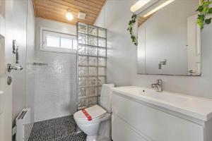 a white bathroom with a toilet and a sink at 0060-Romo-Lakolk-33 in Lakolk +15 photos