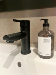 a bottle of soap sitting next to a faucet at Modern Family Cabin In Norefjell Ski-Inout in Surteberg