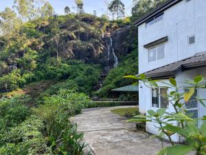 Crimple cottage في نوارا إليا: منزل امام جبل به شلال