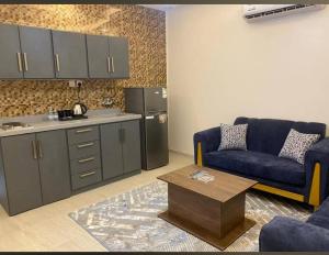 a kitchen with a couch and a table in a living room at فيو إن للشقق الفندقية - المحالة in Abha