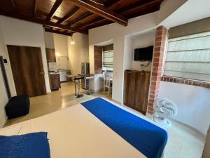 a bedroom with a large bed and a kitchen at Amoblados Medellín Laureles in Medellín