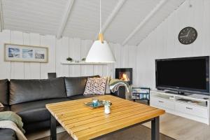 Una sala de estar con un sofá, una mesa y un televisor. en 0278-Romo-Vestergade-3-Ap-23, en Havneby