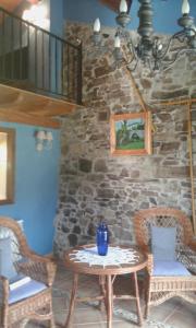 a table and chairs in a room with a stone wall at La casa de atrás in Arancedo +52 photos