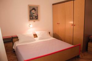 a small bedroom with a bed and a cabinet at Apartment Gulić in Rab