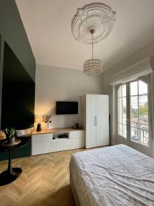a bedroom with a bed and a flat screen tv at Charmant studio, séjour paisible in Châtel-Guyon