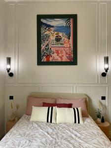 a bedroom with a bed with a picture above it at Charming studio peaceful stay in Châtel-Guyon