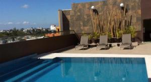 韦拉克鲁斯Veracruz Suites Hotel的建筑物屋顶上的游泳池