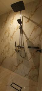 a shower in a bathroom with a stone wall at BuenaSentro Hostel in Manila