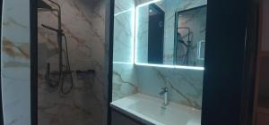 a bathroom with a sink and a shower with a mirror at BuenaSentro Hostel in Manila