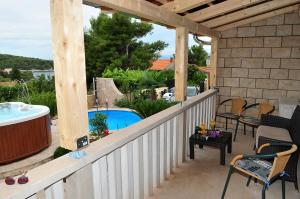 a patio with a tub and a swimming pool at Apartments " Happy villa " in Splitska