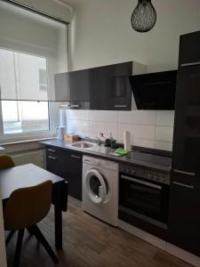 a kitchen with a washing machine and a sink at Urban-Chic-Zentral-Bahnhof-Altstadt-W2 in Wuppertal