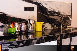 a kitchen counter with utensils on a shelf next to a sink at Sithgiri Drem line cottage in Nuwara Eliya