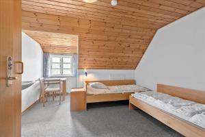 een slaapkamer met twee bedden en een tafel en een stoel bij 0397-Romo-Engvej-40 in Rømø Kirkeby
