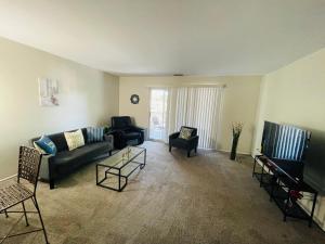 een woonkamer met een bank, stoelen en een tv bij Charming 2BR2BA in Elkins Park Free Parking in Elkins Park