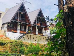 a house with a metal roof and a balcony at Sithgiri Drem line cottage in Nuwara Eliya +19 photos