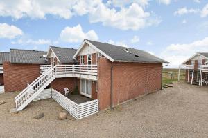 Sønderbyにある0296-Romo-Vestergade-3-Ap-72のポーチに座っている犬がいるレンガ造りの家