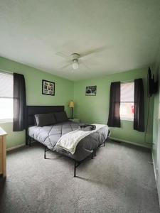 a bedroom with two beds and green walls at Blue Cottage with Game Room Deck & Hot Tub in Logan