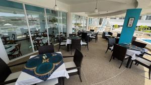 a dining room with tables and chairs and a pool at Aquarius Hotel Boutique in Pampatar