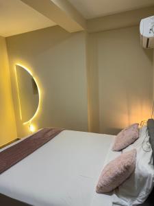 a bedroom with a bed with two pillows on it at Milenio in Manta