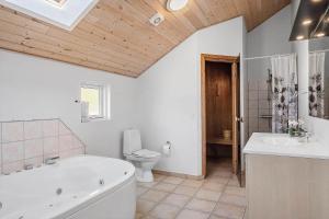 a bathroom with a tub and a toilet and a sink at 0120-Romo-Smafolksvej-61 in Kongsmark +30 photos