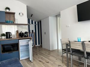 a living room with a table and a kitchen at Blue Apartment B, Dębina in Debina