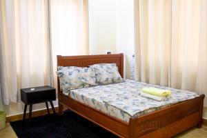 a bedroom with a bed with a wooden frame and curtains at Spacious 2 bedroom home with equipped kitchen in Dar es Salaam