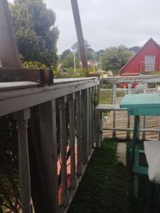 a porch with a blue table and a red barn at Habitación El Jardín Secreto in Isla Negra