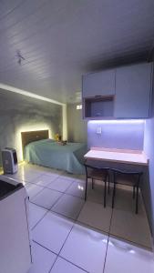 a room with a bed and a table in it at Kitnet Flor do Mar Próximo a Roda Gigante in Ubatuba