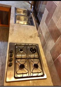 a stove top in a kitchen with a sink at Cabañas LA EMILIA Uspallata Mdz in Uspallata +27 photos