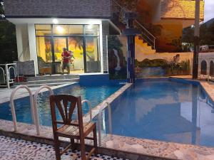 a chair sitting next to a swimming pool in a house at La Maloka in Tingo María