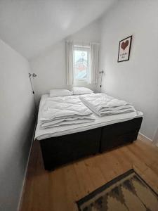 a large bed in a bedroom with a window at 0281-Romo-Vestergade-3-Ap-13 in Havneby