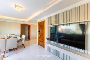 a living room with a large flat screen television at Apto c/ Vista Mar a 200m da Praia TSR0501 in Cururupe