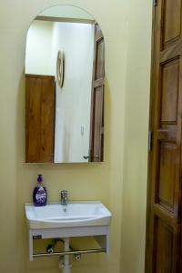 a bathroom with a white sink and a mirror at Spacious 2 bedroom home with equipped kitchen in Dar es Salaam